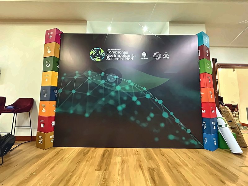 Backing con gráfica y columnas de cubos para un foro de sostenibilidad
