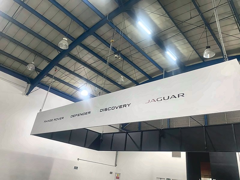Header colgante de gran formato sobre un stand automotriz en un pabellón